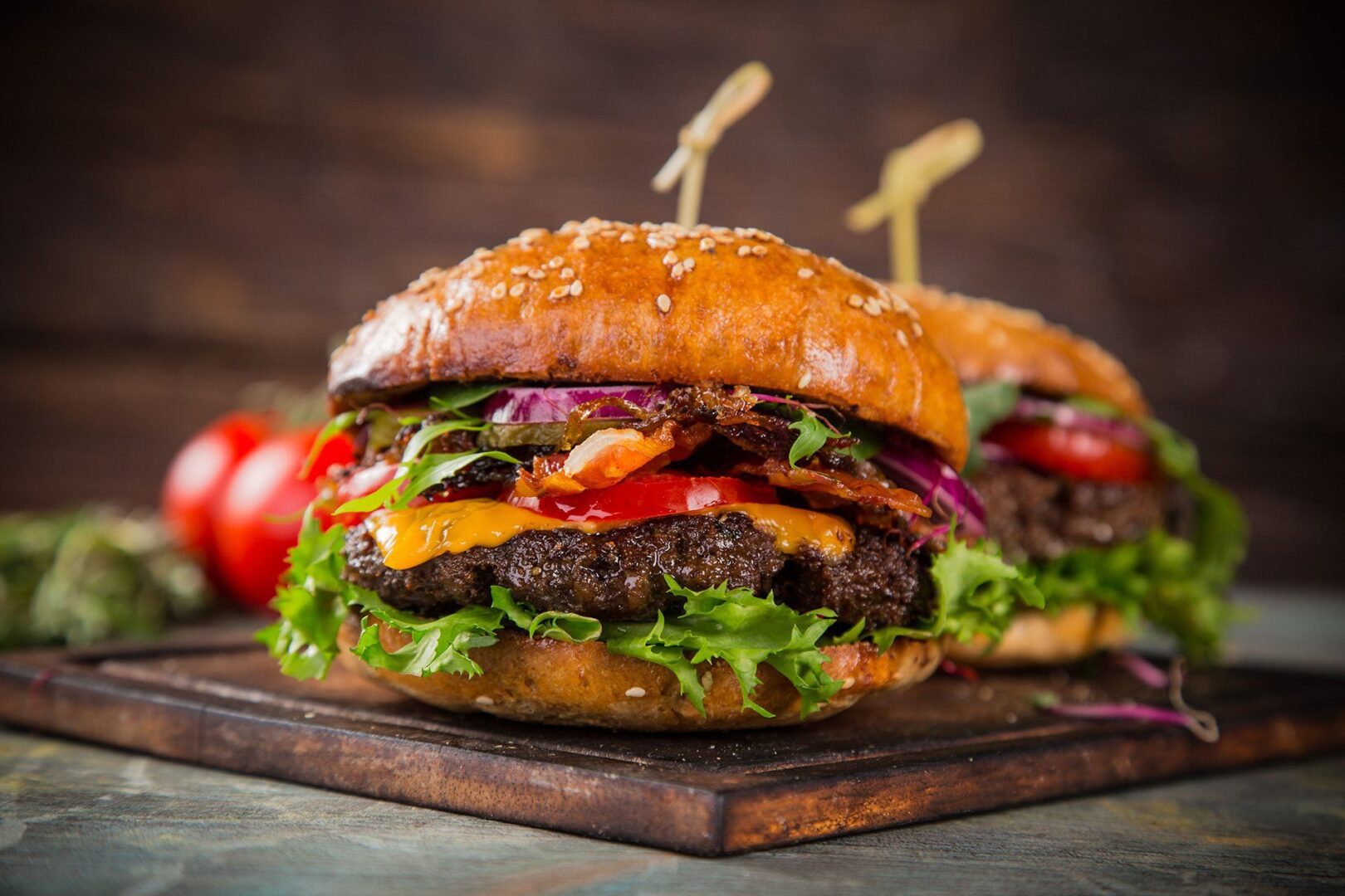 A close up of two burgers on a cutting board